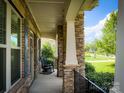 Inviting front porch with stone columns and rocking chairs, perfect for relaxing outdoors at 4006 Tremont Dr, Indian Trail, NC 28079