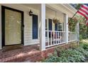 Inviting front porch featuring brick flooring, hanging flower baskets, and charming white railing at 405 Scarborough Ln, Matthews, NC 28105