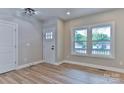 Bright entryway featuring wood-look floors, a white door with glass panes, and a view of the yard at 418 Harrison St, Statesville, NC 28677