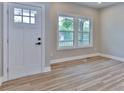 Bright entryway featuring wood-look floors, a white door with glass panes, and a view of the yard at 418 Harrison St, Statesville, NC 28677