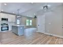 Open concept kitchen with white cabinets, stainless steel appliances, and a large island at 418 Harrison St, Statesville, NC 28677