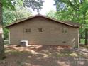 Exterior shot of a single-story brick home featuring windows and an AC unit at 4476 Nc Hwy 200 Rd, Stanfield, NC 28163