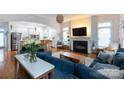 Bright and airy living room featuring hardwood floors, fireplace, and seamless flow into kitchen at 4516 Night Heron Ln, Charlotte, NC 28211