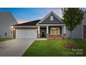 Charming single-story home featuring a stone and gray shingle facade, well-manicured lawn, and a two-car garage at 4619 Harris Elliot Rd, Lincolnton, NC 28092