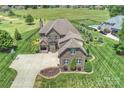 Aerial view of a home with a long driveway, lush landscaping, a pool, and a manicured lawn at 4941 Campobello Dr, Monroe, NC 28110