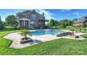 Backyard pool with a pergola, outdoor seating, stone accents, and a lush green lawn at 4941 Campobello Dr, Monroe, NC 28110