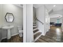 Hallway and half-bathroom featuring modern fixtures and wood-look flooring at 5034 Moss Pine Way, Tega Cay, SC 29708