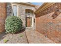 Inviting front entrance with brick pathway, stone archway, and handsome wood door at 5108 Tedorill Ln, Charlotte, NC 28226