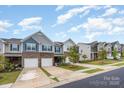 Street view featuring new construction townhomes with garages and manicured lawns at 6011 Chelsea Oaks Rdg, Tega Cay, SC 29708