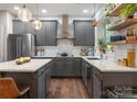 Modern kitchen featuring gray cabinets, stainless steel appliances, and stylish pendant lighting at 611 Meadow Lake Dr, Matthews, NC 28105