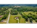 Expansive aerial view of home, surrounding acreage, mature trees, outbuildings, and adjacent neighborhood at 8825 Harris Rd, Concord, NC 28027