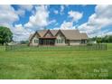 Fenced backyard featuring lush lawn and screened in porch at 8825 Harris Rd, Concord, NC 28027