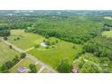 Overhead view captures a large tract of land with a blend of open pasture, dense woodland, and a few residential properties at 9161 Paul Payne Store Rd, Stony Point, NC 28678
