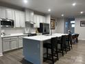 Modern kitchen with white cabinets, stainless steel appliances, and a large island with bar seating at 934 Prince Garrett Way, Denver, NC 28037