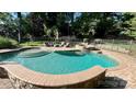 Beautiful backyard pool area with stone accents, comfortable seating, and a relaxing spa at 10338 Hollybrook Dr, Charlotte, NC 28277