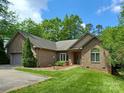 Single-story brick home with a two-car garage, a curved driveway, and verdant landscaping at 1061 Nw 14Th Avenue Nw Dr, Hickory, NC 28601