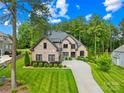 Beautiful brick home with lush landscaping and a long driveway leading to a three-car garage at 107 Blue Ridge Trl, Mooresville, NC 28117