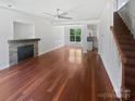 Spacious living room featuring gleaming hardwood floors, a stone fireplace, and an abundance of natural light at 1184 Lempster Nw Dr, Concord, NC 28027