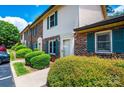 Exterior view of brick and siding townhomes with green shutters, manicured bushes, and blue sky backdrop at 1330 5Th Ne St, Hickory, NC 28601