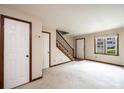 Bright living room featuring neutral carpet, white trim, staircase, and a sunlit window with a view at 1330 5Th Ne St, Hickory, NC 28601