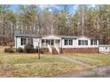 Charming single-story home featuring white siding, a brick foundation, and a welcoming front porch with stair access at 1370 Poole Rd, Salisbury, NC 28146