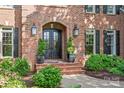 Elegant brick home entrance with a double door, arched entryway, and manicured landscaping at 14701 Jockeys Ridge Dr, Charlotte, NC 28277