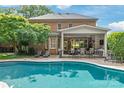 Stunning backyard featuring a large pool, covered patio with seating, and lush landscaping at 14701 Jockeys Ridge Dr, Charlotte, NC 28277