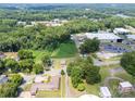Expansive aerial view showing homes, lush trees, commercial buildings, and a view of a lake in the distance at 206 13Th St, Belmont, NC 28012