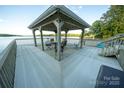 Outdoor area with a covered space, seating, and scenic lake view from the boat dock at 24264 Strand Dr, Albemarle, NC 28001