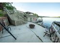Outdoor patio with seating, a fire pit, steps to the lake, and stunning waterfront views at 24264 Strand Dr, Albemarle, NC 28001