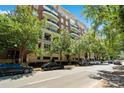 Beautiful condo building exterior with brick facade, balconies, mature trees, and street parking at 400 N Church St # 226, Charlotte, NC 28202
