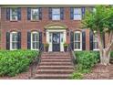 Inviting front entrance with brick steps, black door, and manicured greenery, creating a welcoming first impression at 5508 Kincross Ln, Charlotte, NC 28277