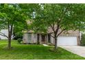 Beautiful brick home with lush green lawn, mature trees, and a two-car garage on a bright day at 5656 Cambridge Bay Dr, Charlotte, NC 28269