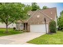 Attractive brick house with a two-car garage, driveway, and landscaped front yard on a pleasant day at 5656 Cambridge Bay Dr, Charlotte, NC 28269