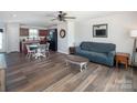Open-concept living room featuring hardwood floors, a ceiling fan, and a combined kitchen-dining area at 5812 Camp Sw Ct, Concord, NC 28025