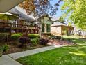 Beautiful backyard featuring a wooden deck, patio, lush landscaping, and mature trees at 617 Peace Haven Rd, Kannapolis, NC 28083