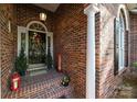 Close-up of a welcoming front door with decorative wreath and elegant brick surround at 617 Peace Haven Rd, Kannapolis, NC 28083