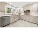 Bright kitchen featuring white cabinets, stainless steel appliances, tile backsplash and a large window overlooking the yard at 64 Timberidge Dr, Lake Wylie, SC 29710