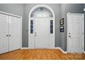 Bright foyer with hardwood floors, white front door with sidelights, and two white closet doors at 6717 Bickham Ln, Charlotte, NC 28269