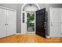 Spacious foyer with hardwood floors, a black front door, and two white closet doors, creating an inviting entrance at 6717 Bickham Ln, Charlotte, NC 28269