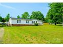 Spacious lawn in front of a single-story home with a covered parking area, complemented by vibrant green grass at 745 Rock Castle Dr, York, SC 29745