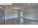 Open living room with hardwood flooring, recessed lighting, and a view of the backyard through a window at 8025 Kennesaw Dr, Gastonia, NC 28056