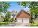 Lovely home with a well-kept lawn, mature trees, a brick accent wall, and a two-car garage at 8709 Huntland Ct, Charlotte, NC 28277