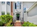 Close-up of the front door with a decorative wreath and well-maintained landscaping surrounding the entrance at 8709 Huntland Ct, Charlotte, NC 28277