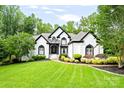 Charming home with a beautifully landscaped front yard, mature trees, and an inviting entrance at 1001 Berwick Ct, Waxhaw, NC 28173