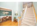 Welcoming entryway with a carpeted staircase, hardwood floors, and a view into the dining room at 11724 Brambleton Ct, Charlotte, NC 28277
