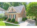 Brick home with a side-entry garage, black shutters, and a well-manicured lawn, offering great curb appeal at 11724 Brambleton Ct, Charlotte, NC 28277