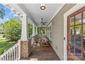 Relaxing covered front porch featuring ceiling fans, rocking chairs, and lovely views of the surrounding neighborhood at 1241 Rollins Ave, Charlotte, NC 28205