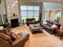 Spacious living room featuring a fireplace, large windows, and neutral carpet at 12610 Angel Oak Dr, Huntersville, NC 28078