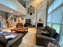 Bright living room features soaring ceilings, fireplace, large windows, and neutral carpet at 12610 Angel Oak Dr, Huntersville, NC 28078